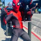 Person in Spider-Man costume with Black Panther teddy bear on street pose