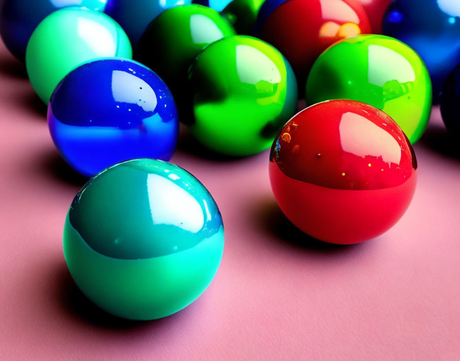 Vibrant glossy balls on pink surface with shiny reflections