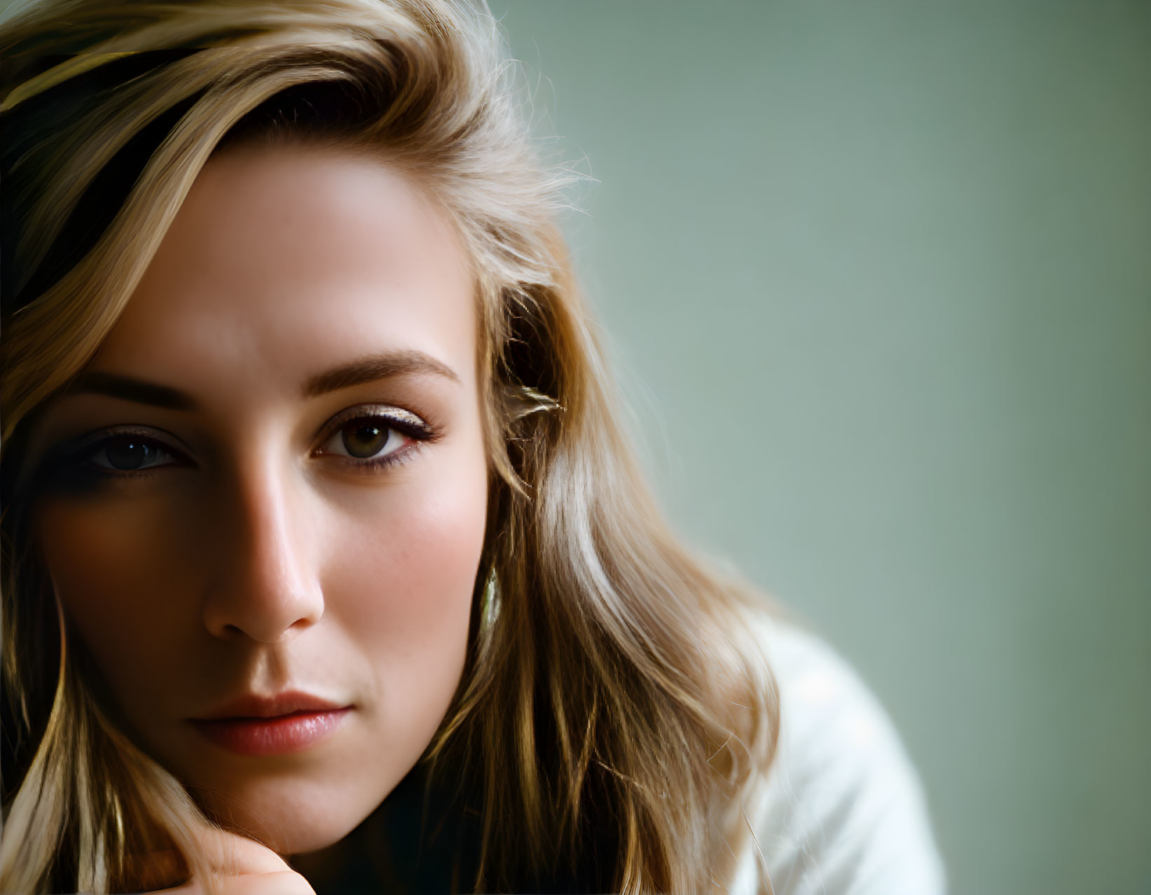 Blonde Woman Contemplating Against Green Background