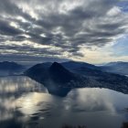 Surreal landscape with undulating mountains and reflective water surface