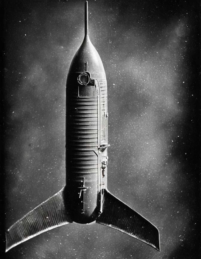 Vintage rocket with large fins and rounded nose cone in black-and-white photo