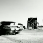 Futuristic vintage car with circular doors on snowy ground near industrial buildings