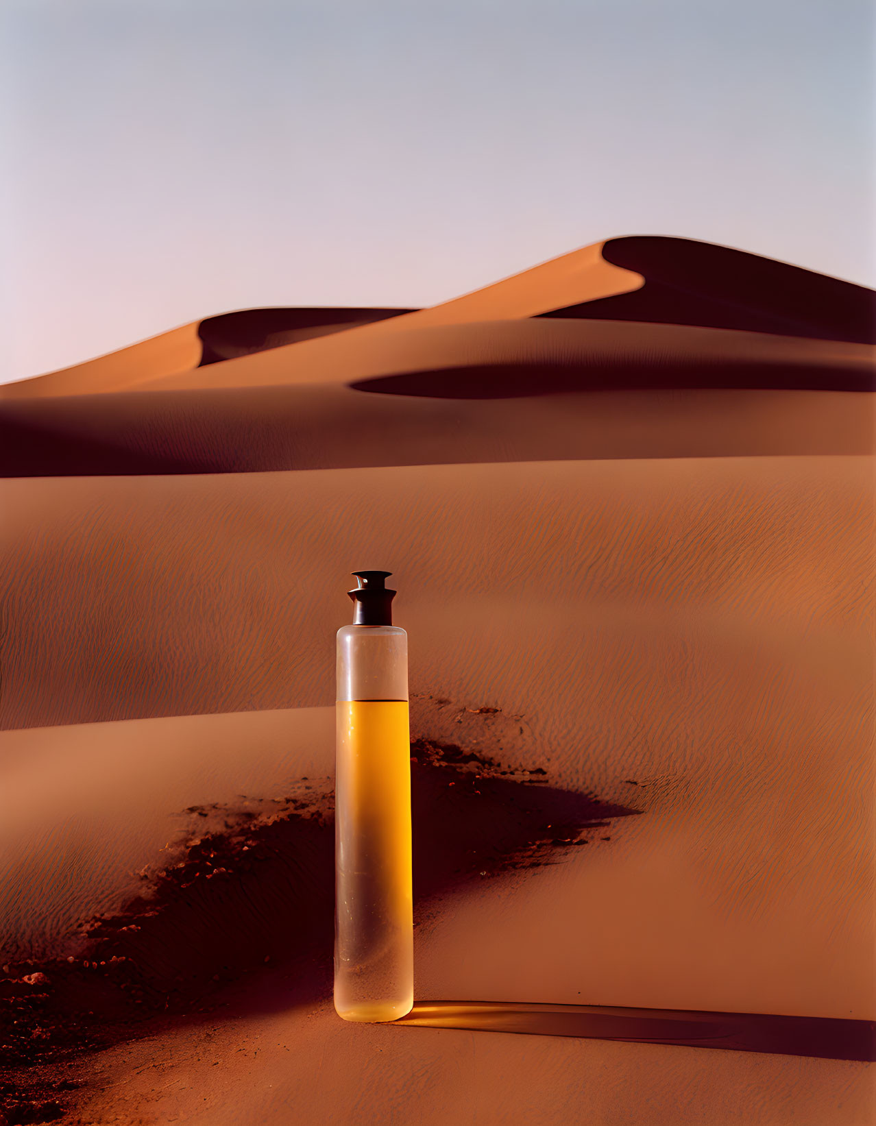 Yellow Liquid Bottle Against Desert Dunes and Sky