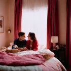 Couple sitting closely on bed in cozy, warmly lit bedroom