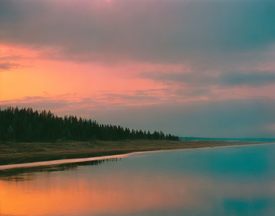 Tranquil sunset with vibrant pink and blue skies reflecting on calm lake