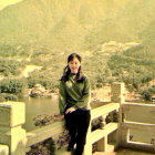 Traditional Attire Woman Smiling on Bridge Overlooking Ancient Pagoda