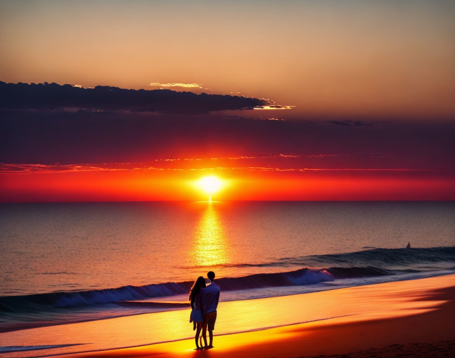 Couple watching vibrant sunset on beach with ocean waves.