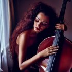 Curly-Haired Woman Holding Cello in Dramatic Lighting