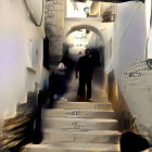 Historic cobblestone alleyway with whitewashed walls and street lamps at dusk