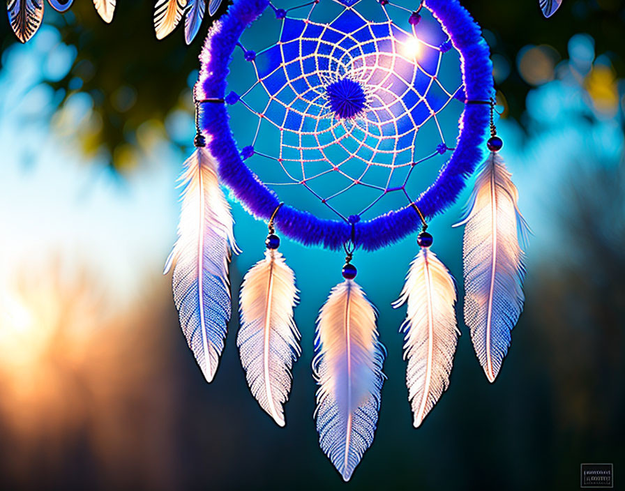 Colorful dreamcatcher with blue beads and feathers on bokeh-lit backdrop