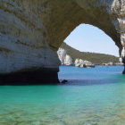 Tranquil coastal landscape with natural rock archway and turquoise sea