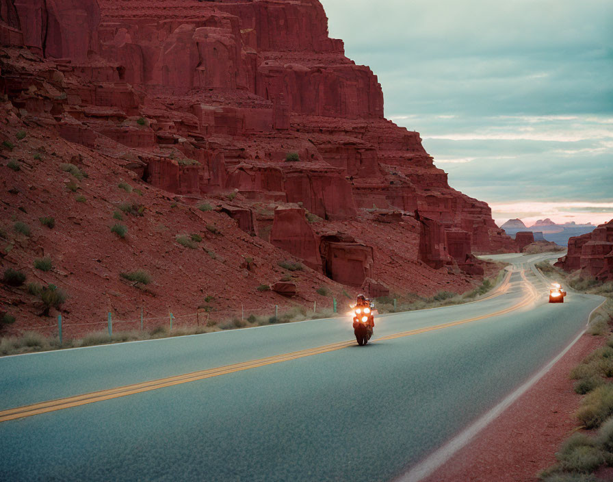 Scenic landscape with winding road and motorcycles amid red rock formations