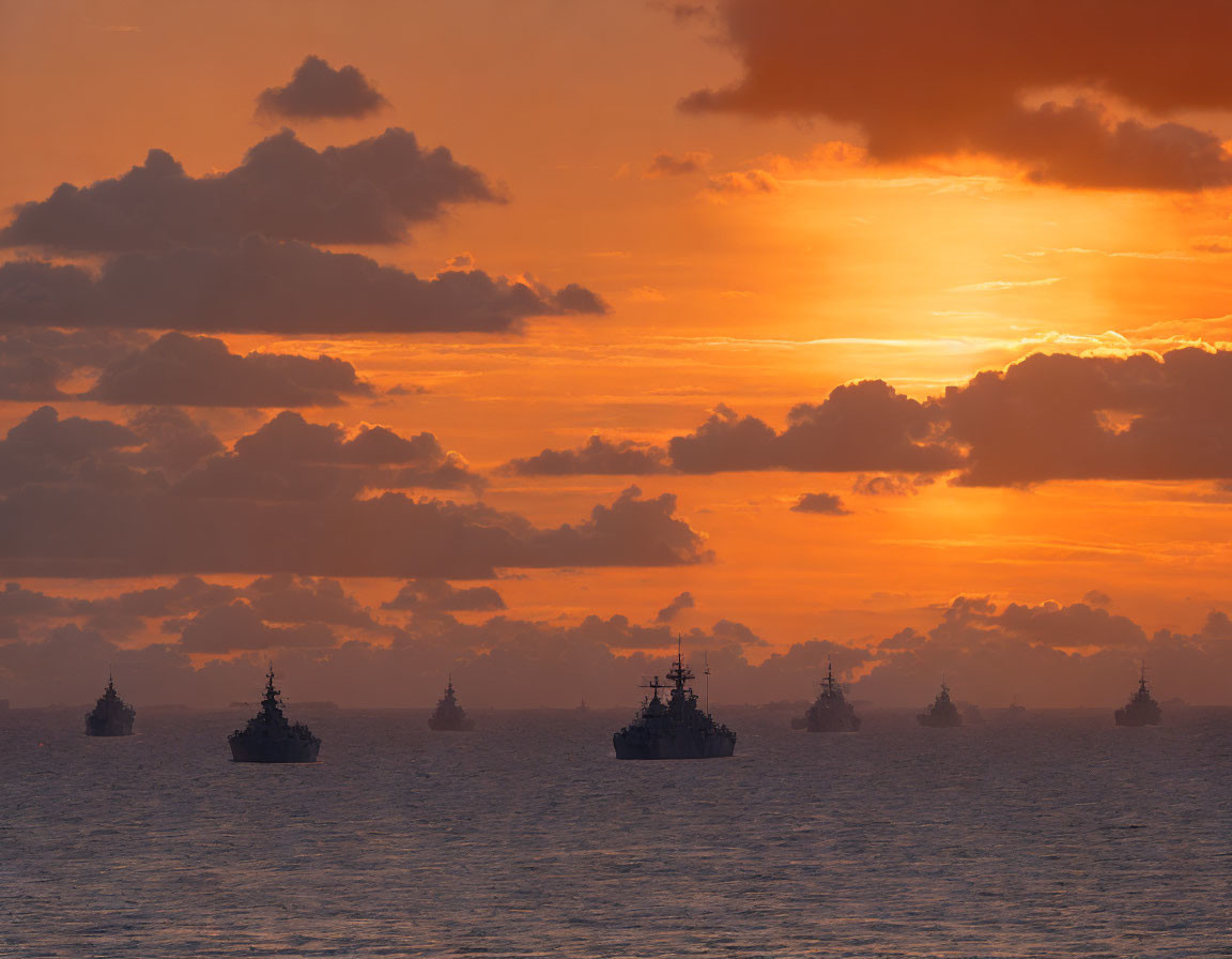 Warships silhouetted against orange sunset sky and ocean reflections.