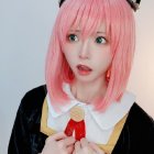 Cosplayer with Pink Hair and Cat Ears in Surprised Expression Holding Object