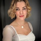 Portrait of woman with marcel wave hairstyle and pearl necklace in white dress