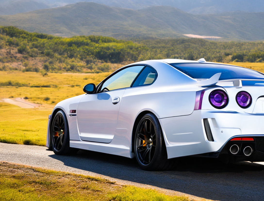 White Sports Car with Rear Spoiler and Quad Exhaust in Mountain Landscape