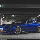 Blue Sports Car with Glowing Accents in Industrial Indoor Setting