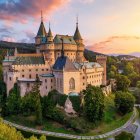 Fantastical castle on lush cliff in golden sunlight