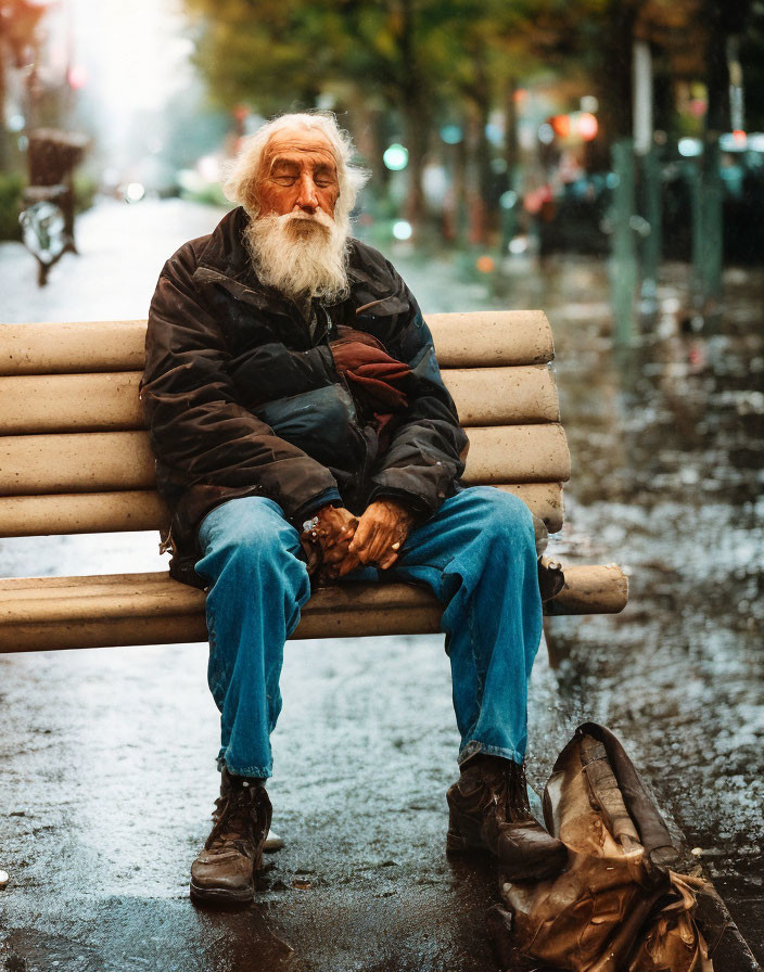 Elderly Bearded Man Sitting on Wet Bench in Rainy Street