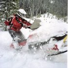 Futuristic gold and black armored rider on modified snowmobile in snowy forest