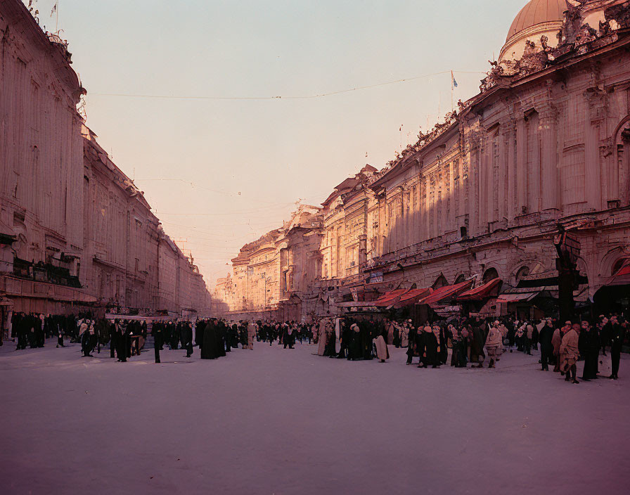 Snow-covered urban square with market stalls and elegant buildings at sunset