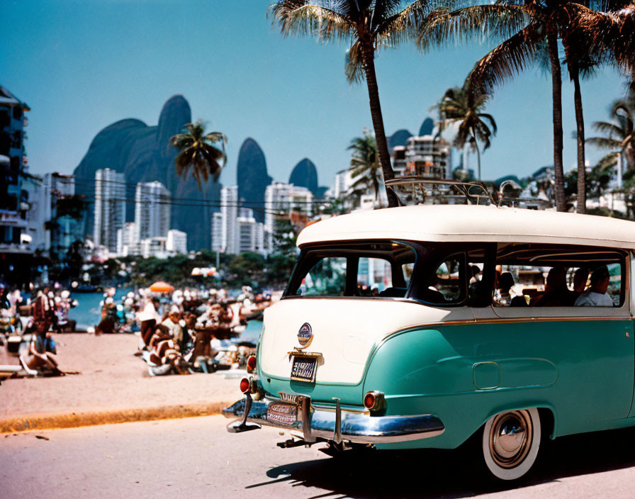 Classic Car Parked at Tropical Beach with Palm Trees and Mountain Peaks