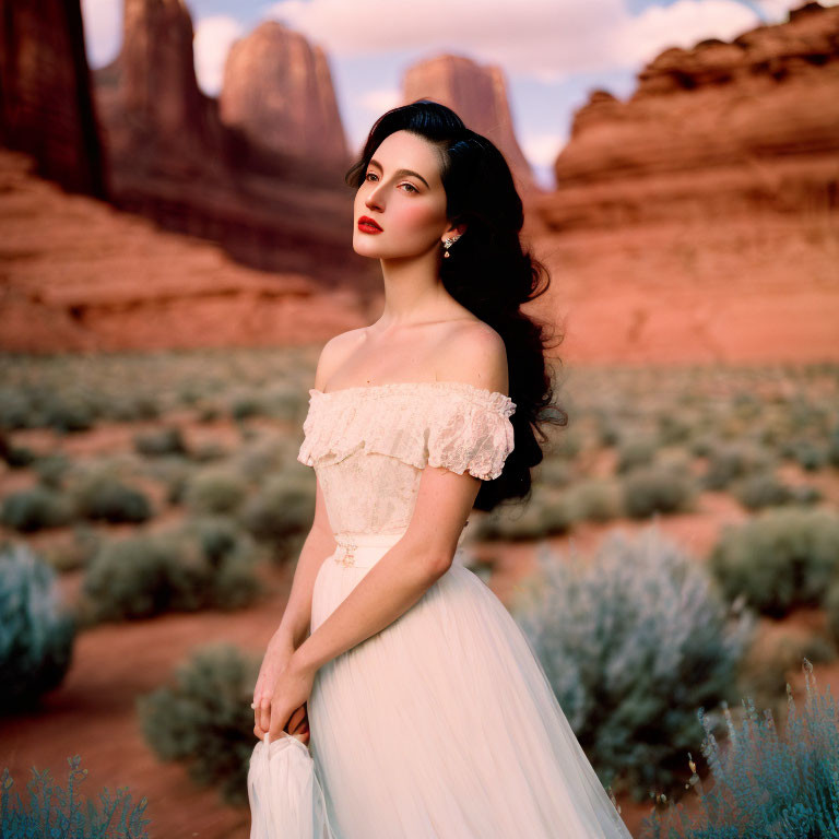 Woman in White Dress Standing in Desert with Red Rock Formations