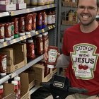 Bearded man with staff amidst colorful religious artifacts