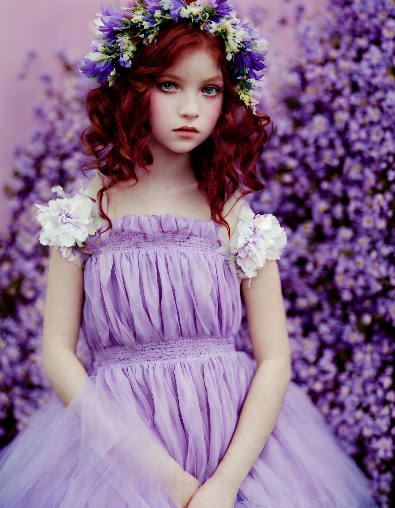 Red-haired girl in purple dress with floral wreath among purple flowers