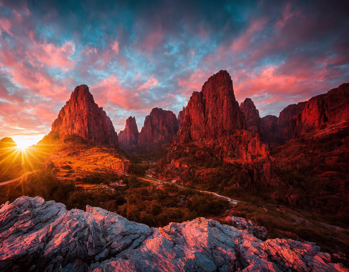 Scenic sunset over rugged mountain peaks with winding road