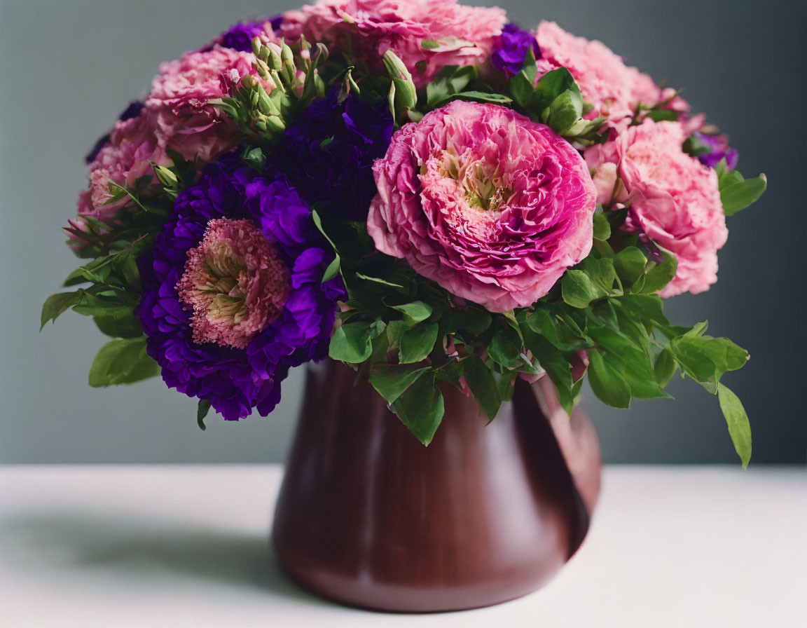 Pink and Purple Flower Bouquet in Brown Vase on Grey Background