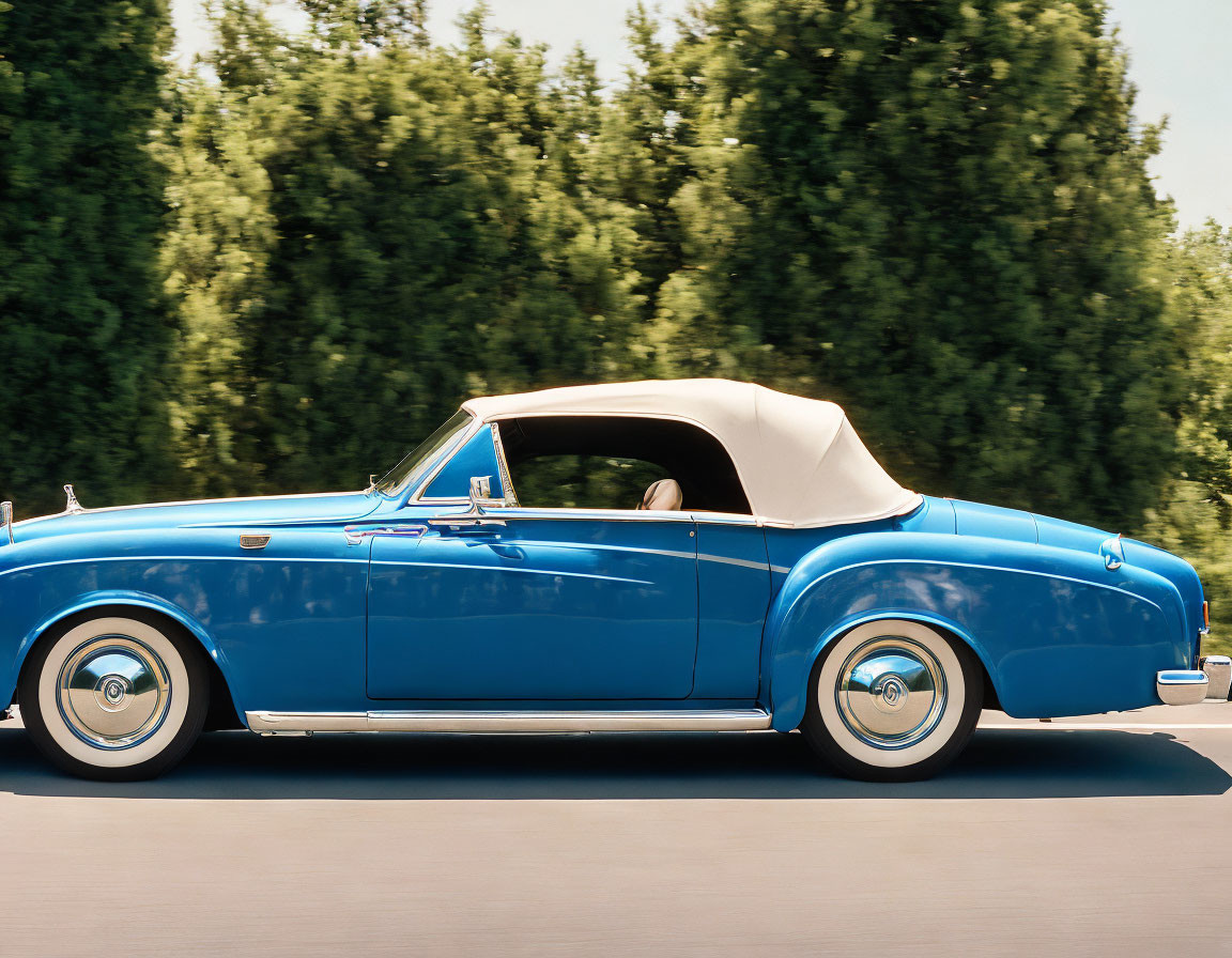 Vintage Convertible Car with Blue Body and White Sidewall Tires in Motion