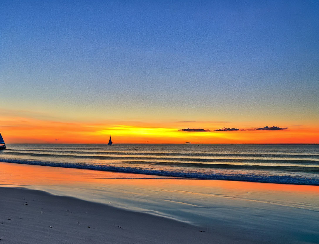 Scenic beach sunset with orange and blue hues, gentle waves, and distant sailboat