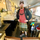 Traditional Scottish kilt-clad man with beer in Art Nouveau bar scenery