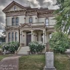 Victorian-style house with grand staircase and blue roof in scenic setting