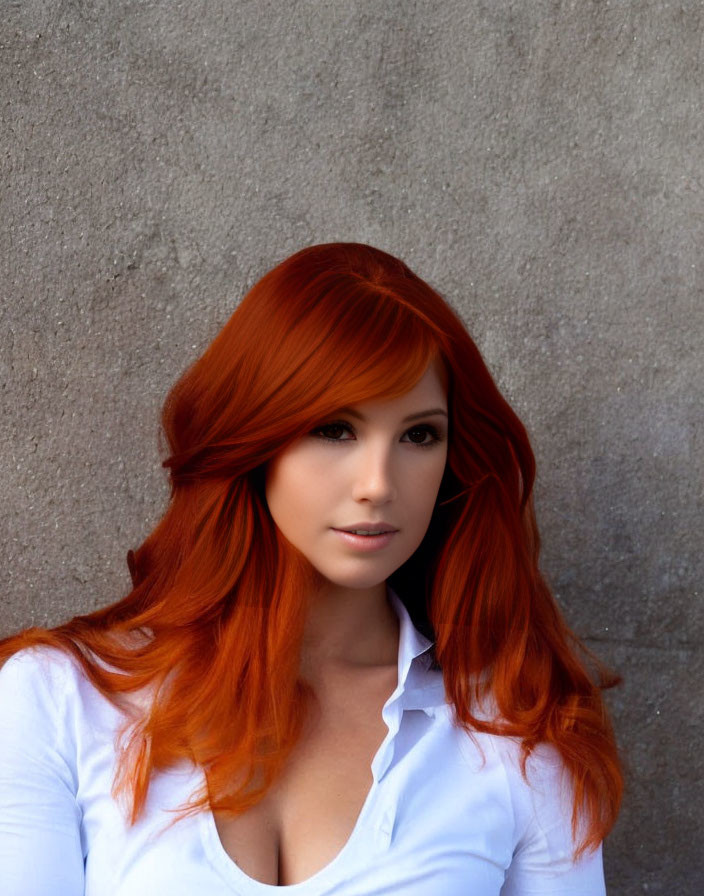 Red-haired woman in white blouse against gray textured wall