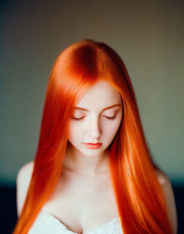 Vibrant red-haired woman portrait on soft blue background