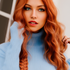 Woman with Red Hair and Blue Eyes in Blue Sweater and Gold Earrings Portrait