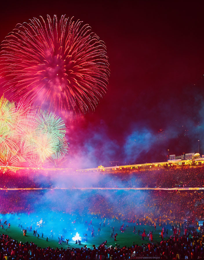 Colorful fireworks display above crowded stadium at night