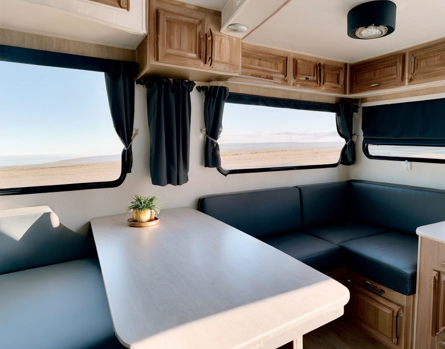 Modern RV Interior with Dinette Booth, Wooden Cabinets, & Desert Landscape View