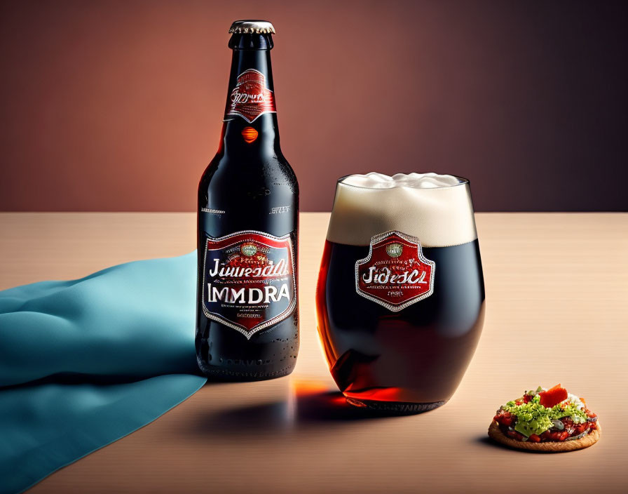 Dark Beer Bottle and Glass with Vintage Label and Frothy Head on Table with Appetizer and Blue Cloth