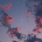 Tranquil sunset sky with pink clouds and early stars on deepening blue gradient