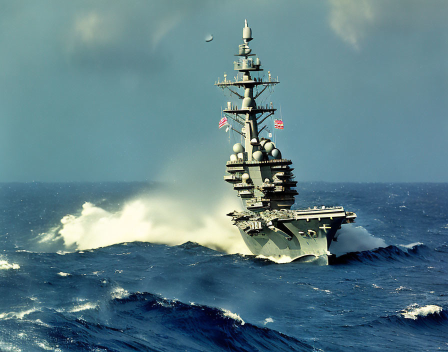 Military aircraft carrier in rough sea with large waves and spray under cloudy sky