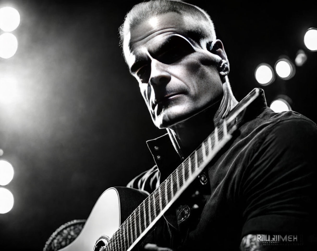 Monochrome image of musician with guitar and intense gaze