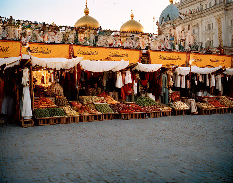 Vibrant outdoor market with colorful stalls and ornate architecture.