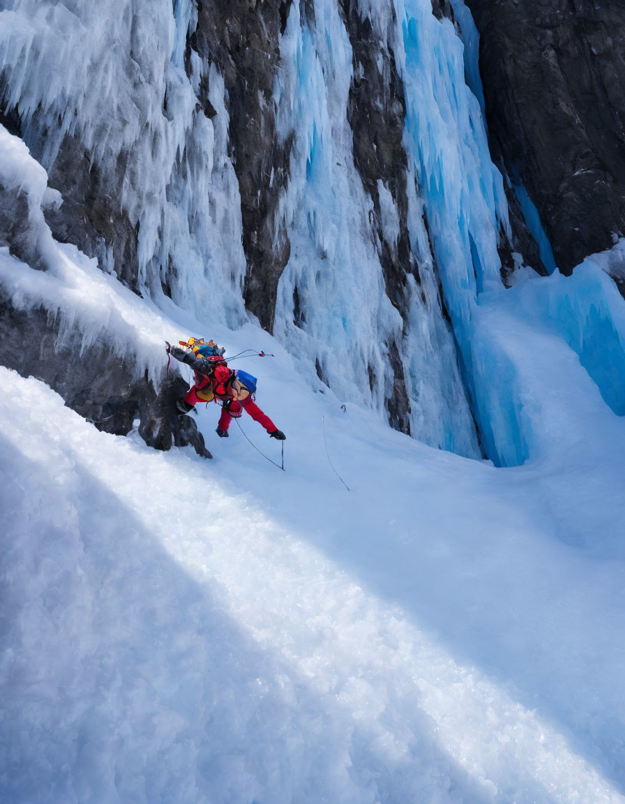 Snowy slope climber with ice axes near blue ice formations.