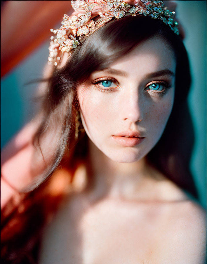 Portrait of woman with blue eyes in floral headpiece under warm sunlight