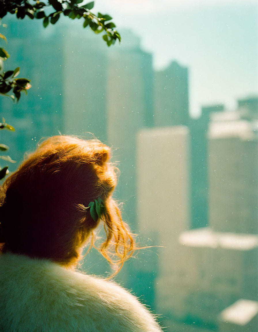 Red-Haired Woman Gazing at Cityscape in Warm Sunlight