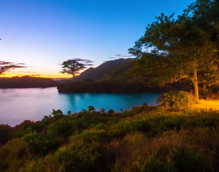 Serene Twilight Scene: Lake, Trees, Warm Light, Blue Sky