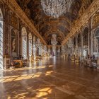 Luxurious Hall with Wooden Floor Designs, Golden Walls, Large Windows, and Chandeliers